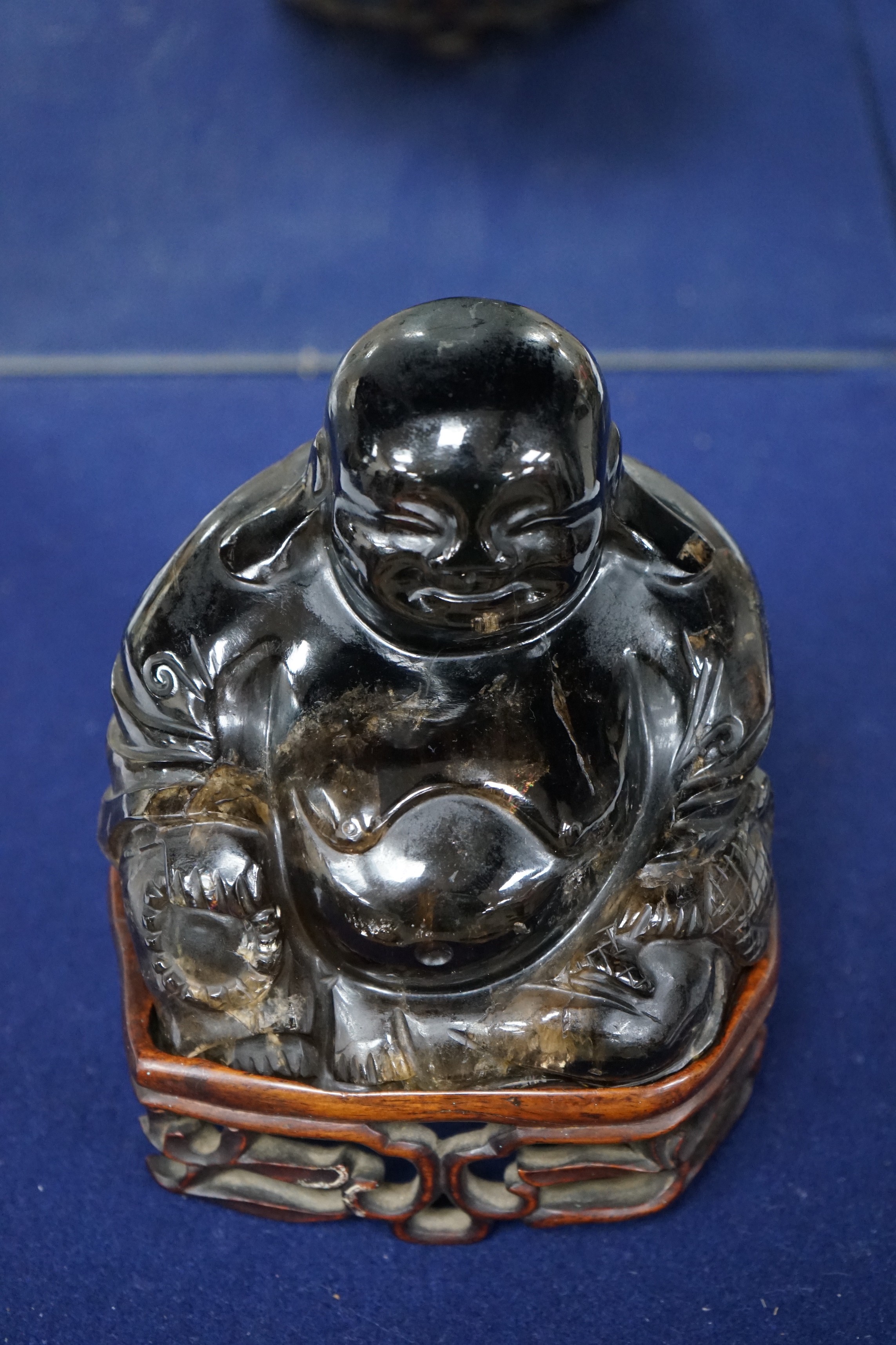 A large Chinese smoky quartz figure of Budai, 17cm tall including wood stand